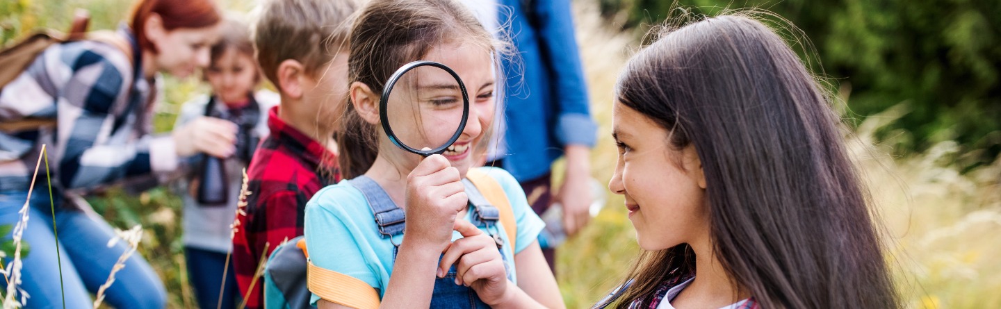 Sommerkinder und Sommerteens Header: Einige Kinder sind gemeinsam mit ihren Betreuern in der Natur unterwegs.