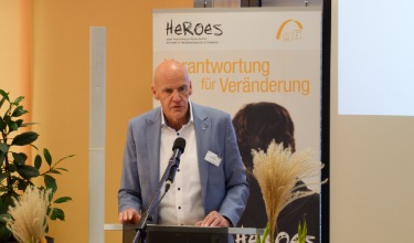 Josef Weingärtner, der Geschäftsführer der gfi bei seiner Begrüßung am HEROES Fachtag 2023 in Schweinfurt am Podium