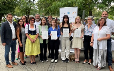 Petra Loibl (MdL Bayern) steht zusammen mit drei Schülerinnen, die das Zertifikat als W hoch drei Wissenträgerinen in den Händen halten.