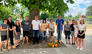 News- Bild: Mehrere Personen posieren vor einem Baum stehend